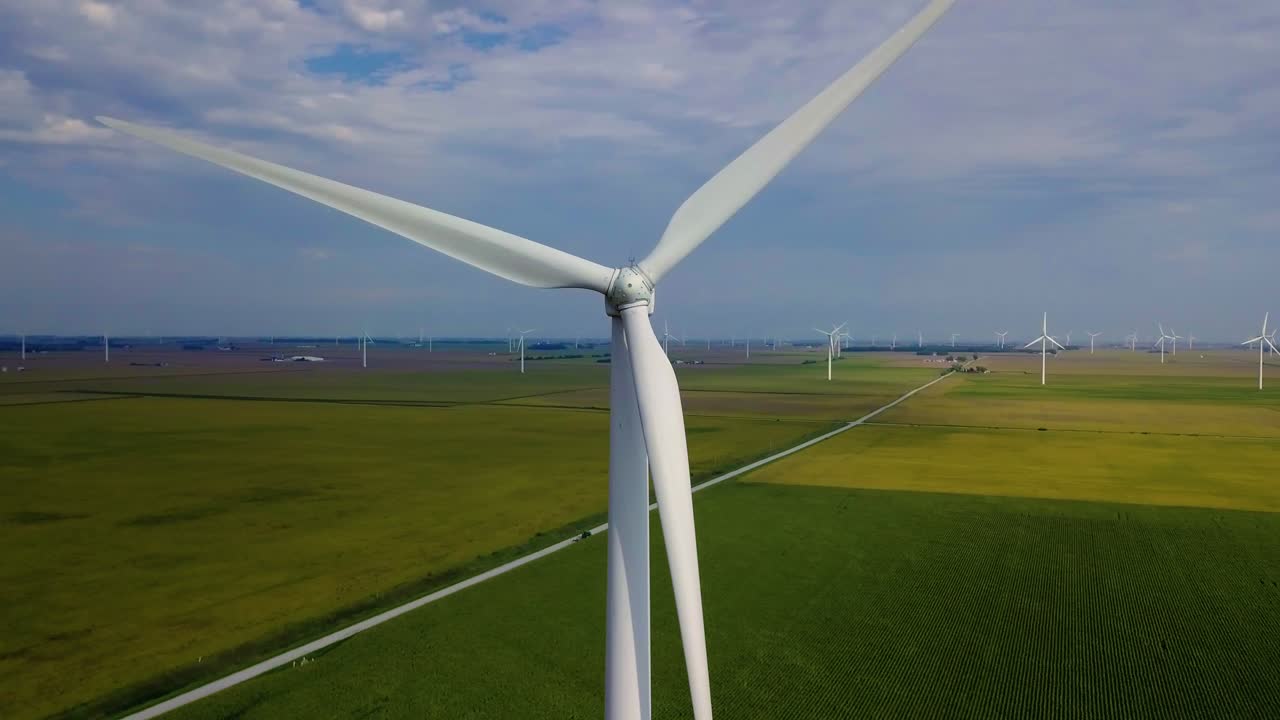 Close up aerial view orbiting sustainable energy wind turbine on Lafayette agricultural farmland, Indiana countryside