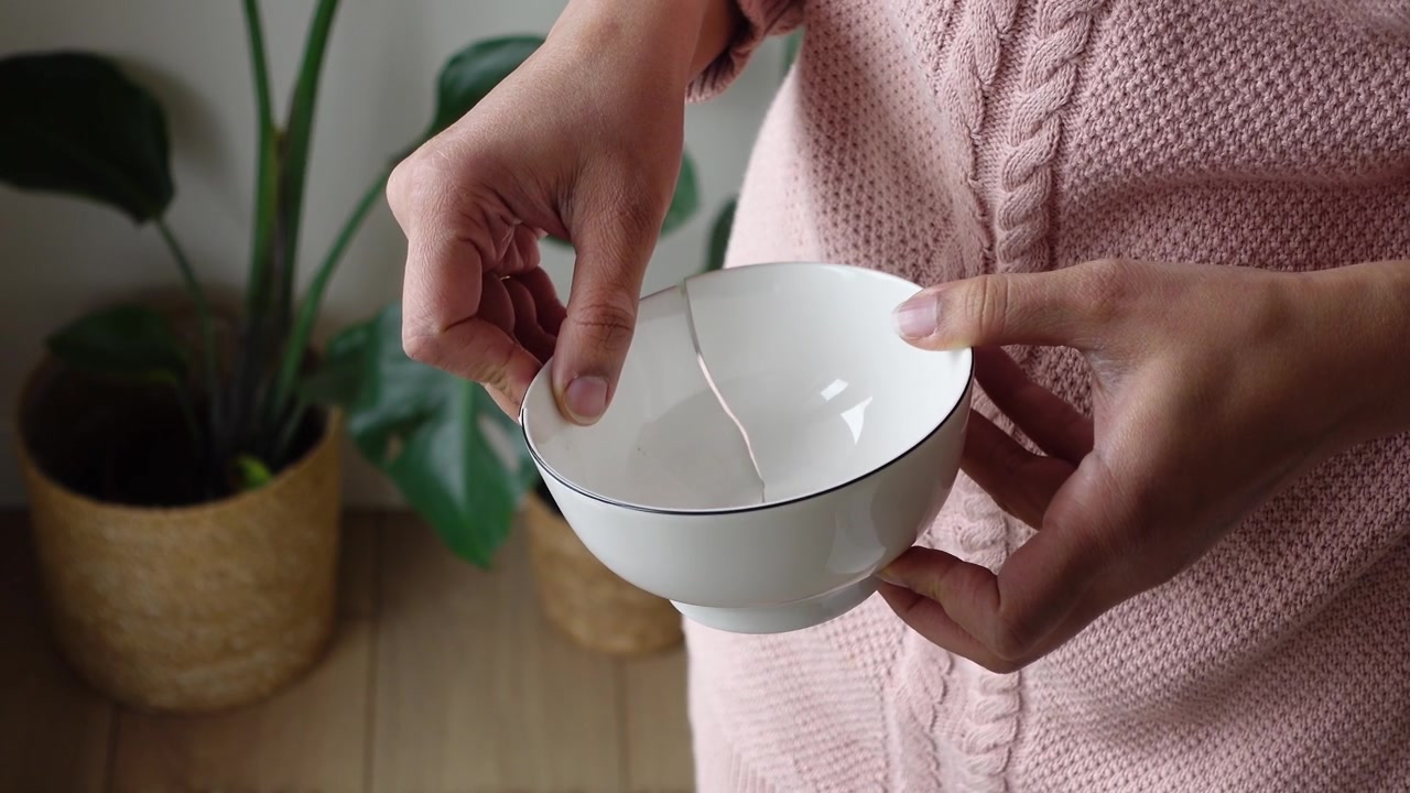 Person Holding a Broken Ceramic Bowl