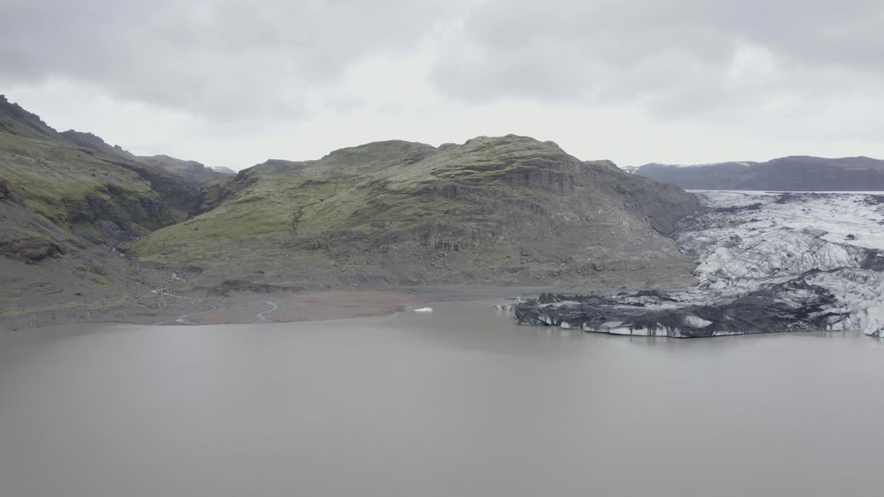 아이슬란드의 solheimajokull 빙하에 있는 라군 위로 공중 드론 보기 - 역방향, 드론 샷