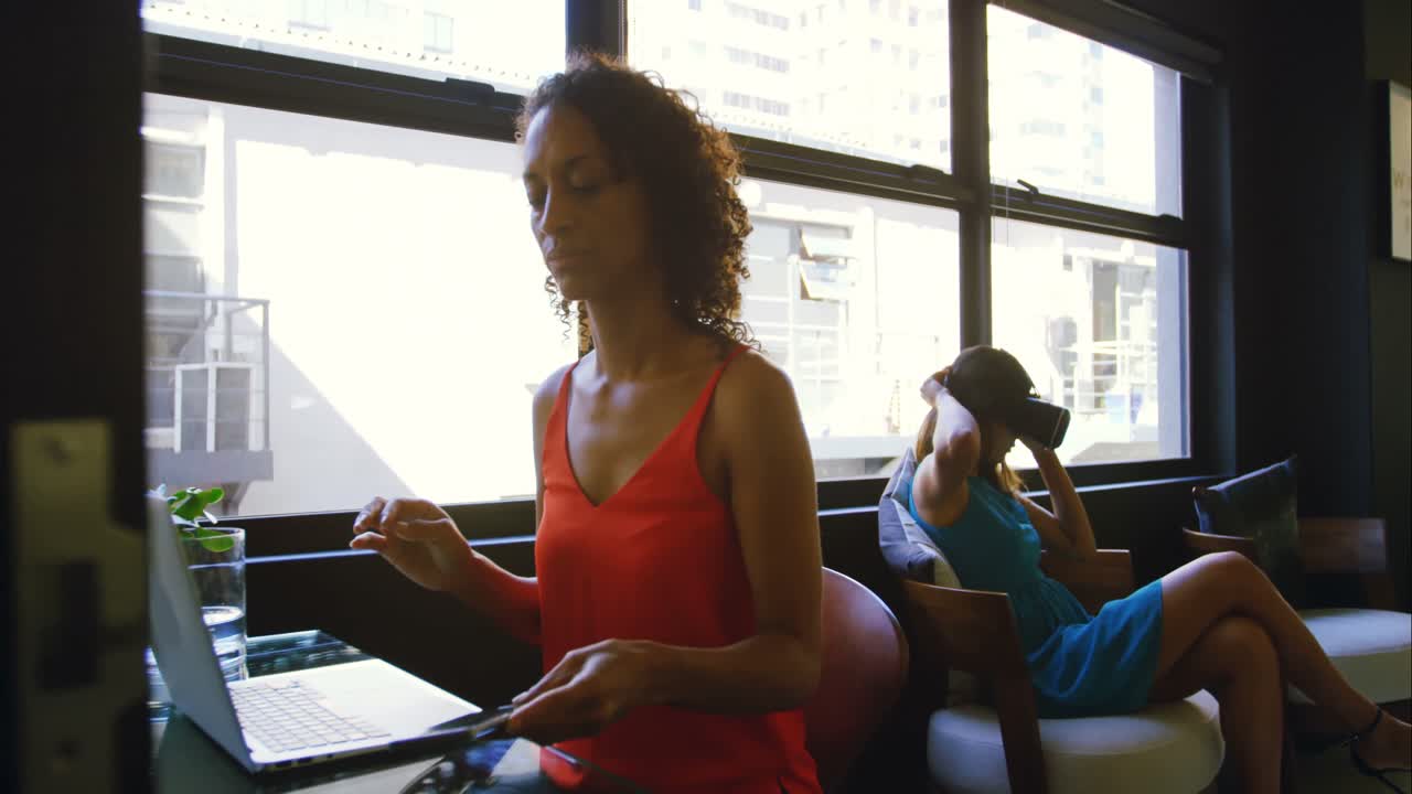 Business colleagues using mobile phone and digital tablet at desk 4k