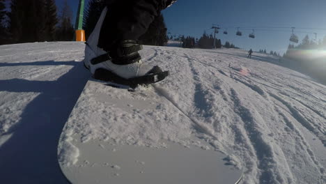 a closeup of a snowboarder's legs sliding on a snowy slope