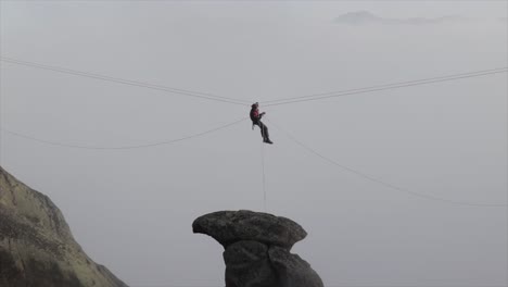 rock climber on a zip line fixing the ropes and equipment