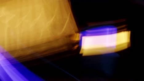 the blurry motion of blue and yellow streak light is fast moving on a black background.