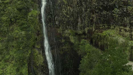 drone shot moving up to the top of a waterfall