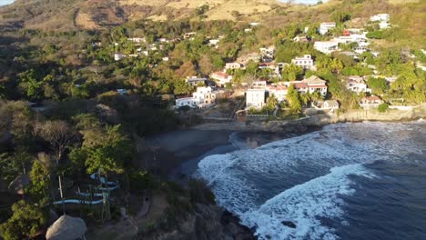 Aerial-drone-shot-of-ocean-waves-crashing-against-the-shore-in-El-Salvador