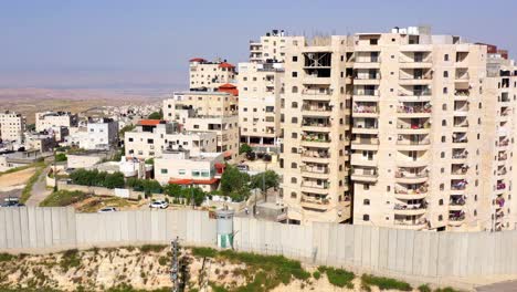 urban landscape with a tall security wall and multi-story residential buildings