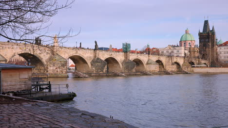 Orilla-Del-Río-Vltava-De-Adoquines-Debajo-Del-Puente-De-Piedra-Charles,-Ciudad-De-Praga