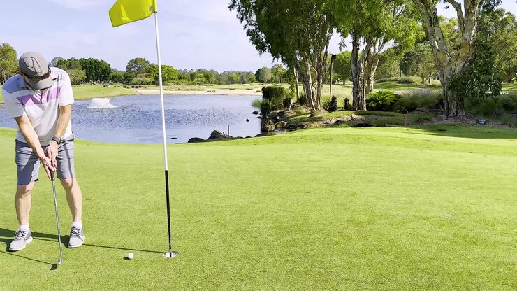 Golfista che esegue un putt su un panoramico campo da golf della Gold Coast