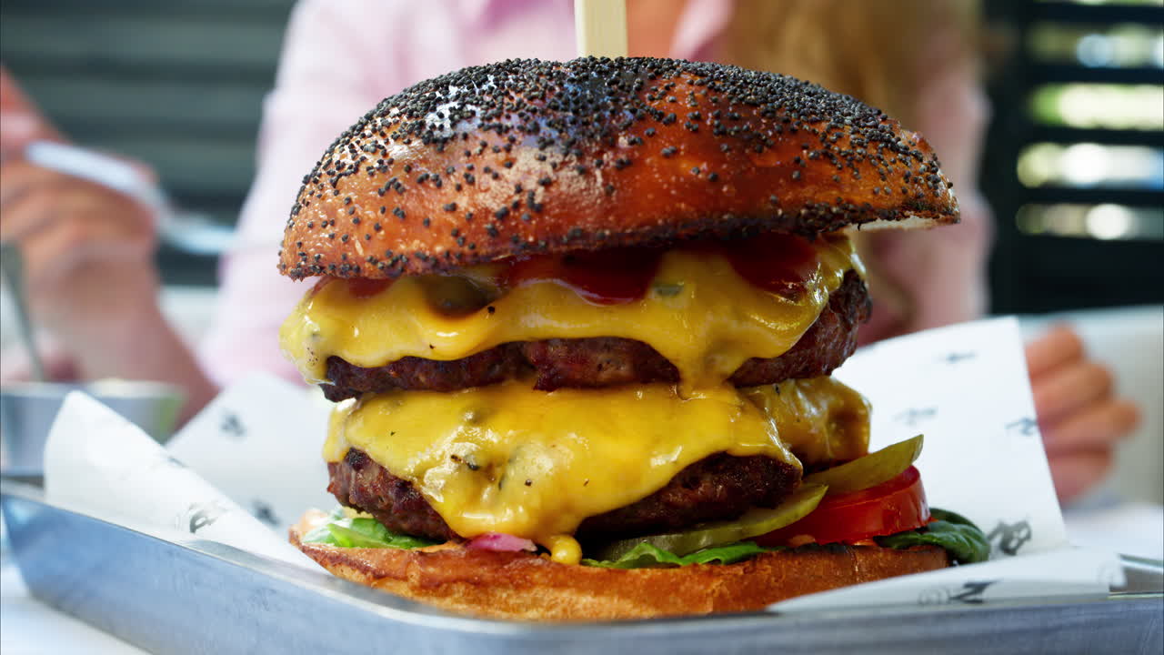 Close up of a big hamburger on a table at a restaurant