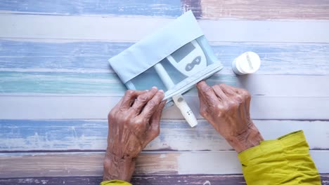 elderly person using blood glucose meter