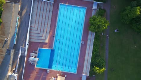 Magic-aerial-top-view-rotation-flight-Berlin-city-Public-swimming-pool-Germany-in-Europe,-summer-day-2023