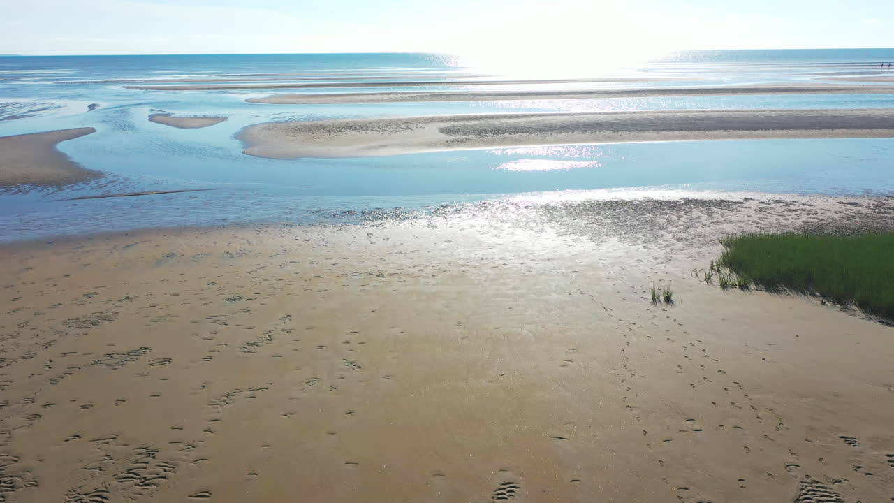 바다 위로 태양을 향해 날아가는 모래 언덕과 썰물 때 베이 사이드 해변의 아름다운 케이프 코드 베이 공중 드론 영상, 공개 샷