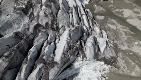 Drohnenaufnahme-Zeigt-Den-Pasterze-Gletscher-Und-Wasserströme,-Die-Die-Talwände-Hinunter-In-Den-Gletschersee-Im-Hintergrund-Strömen