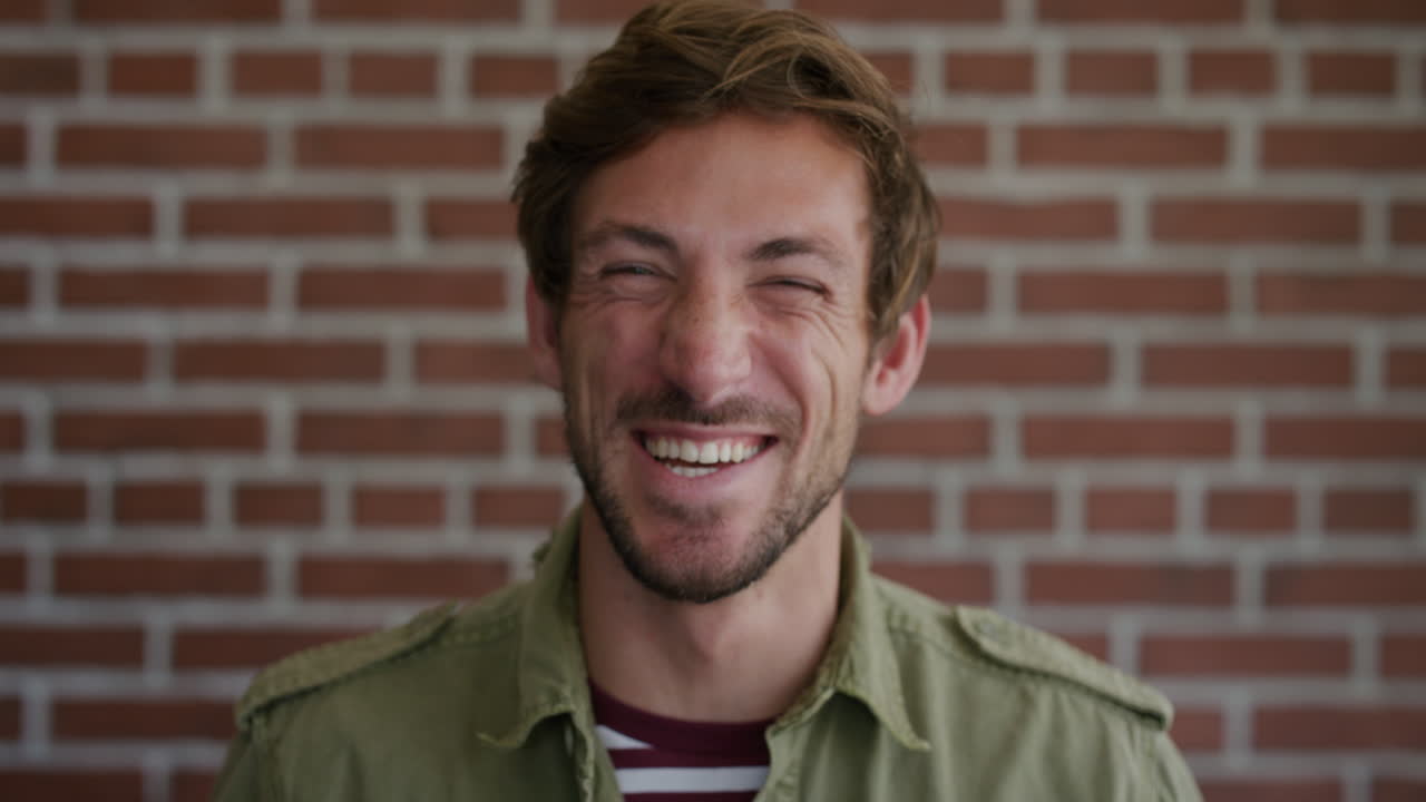 초상화 매력적인 젊은 백인 남자가 웃고 행복한 즐거운 백인 남자가 벽돌 벽 배경에