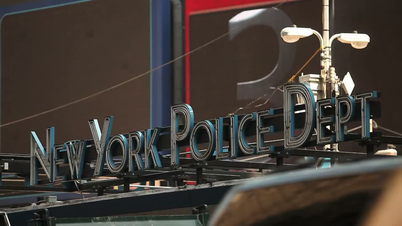 뉴욕시의 뉴욕 경찰국 표지판 앞에서 교통이 지나간다.