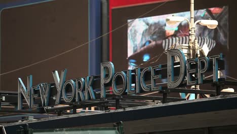 el tráfico pasa antes de una señal para el departamento de policía de nueva york en la ciudad de nueva york