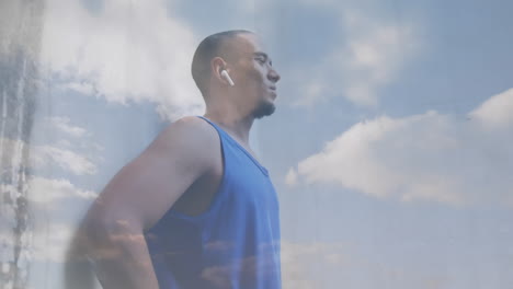 animación de nubes sobre atleta masculino usando auriculares inalámbricos y reloj inteligente haciendo ejercicio al aire libre