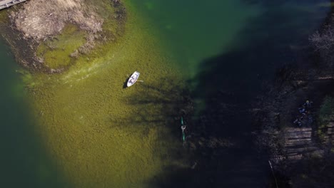 AERIAL-Boat-and-Kayak-in-a-Blue-Lake-in-Vilnius,-Lithuania