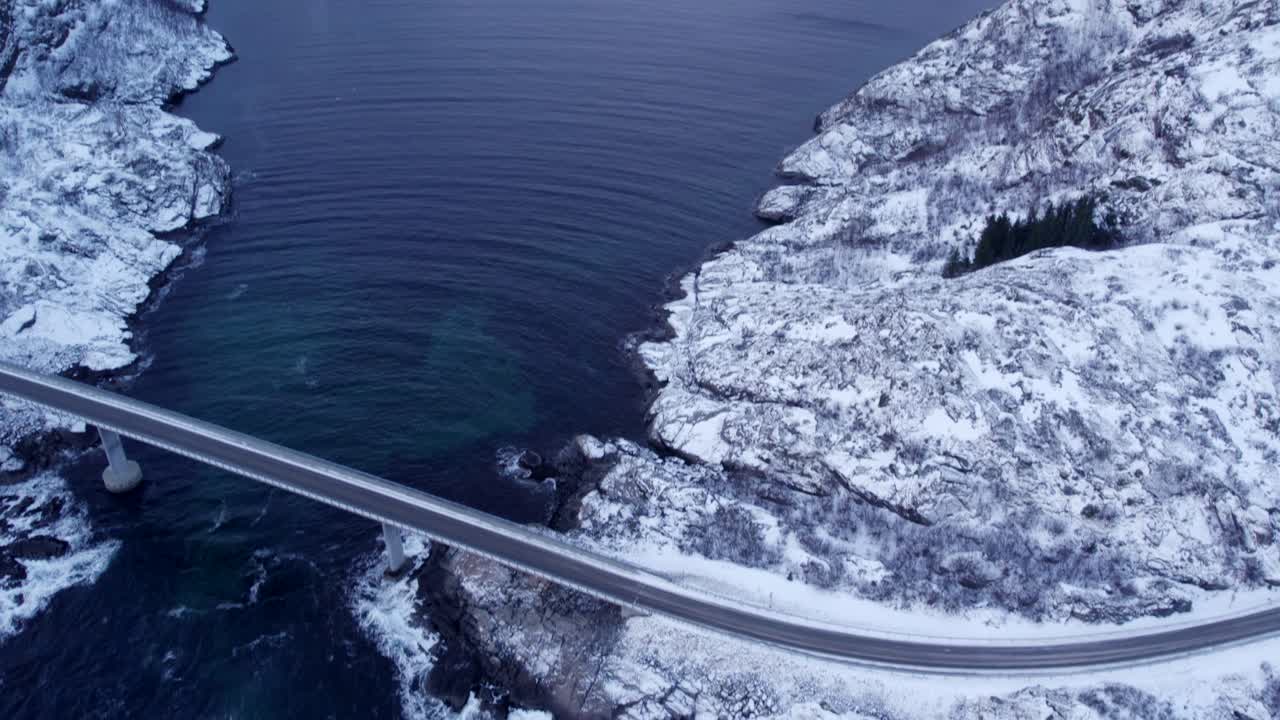 노르웨이 피오르드의 순수한 자연과 어두운 물 위에 구부러진 현대적인 다리의 공중 풍경