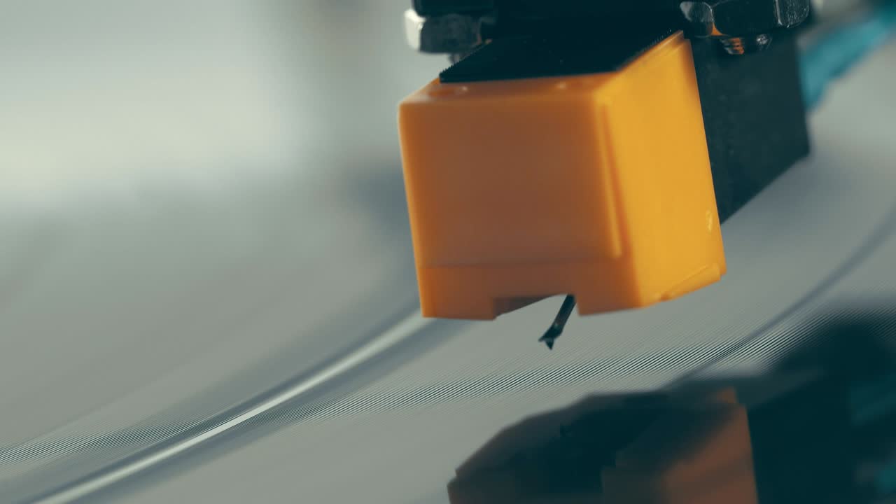 비닐 플레이어 턴테이블: 회전하는 비닐 레코드의 조각, 바늘을 클로즈업으로 가진 스타일러스, 바늘과 비닐 판을 클로스업으로 멈추는.