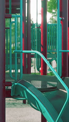 a closeup of a green slide and red playground equipment