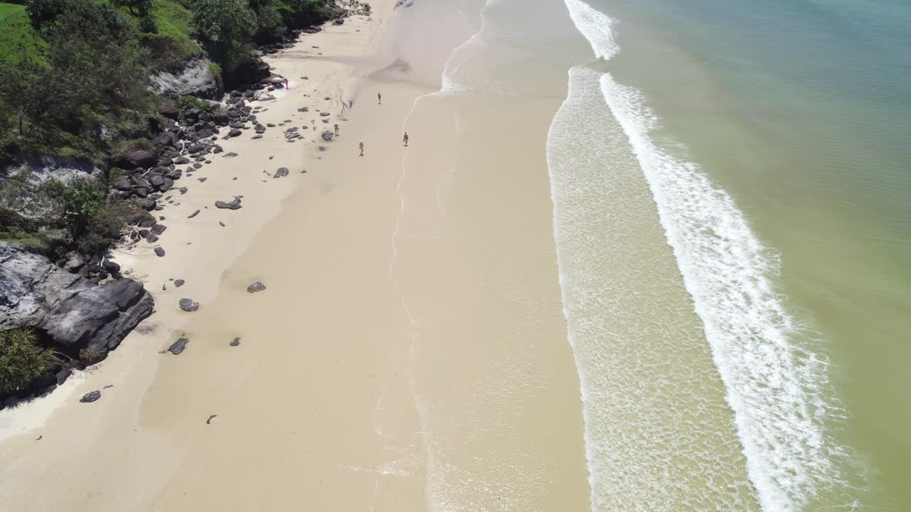 плещущиеся на песке волны и прогуливающиеся летом пляжники