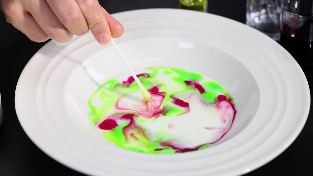 활기찬 색이 막대기로 우유에 회전합니다.