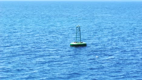 green buoy floating on the blue waters of the ionian sea