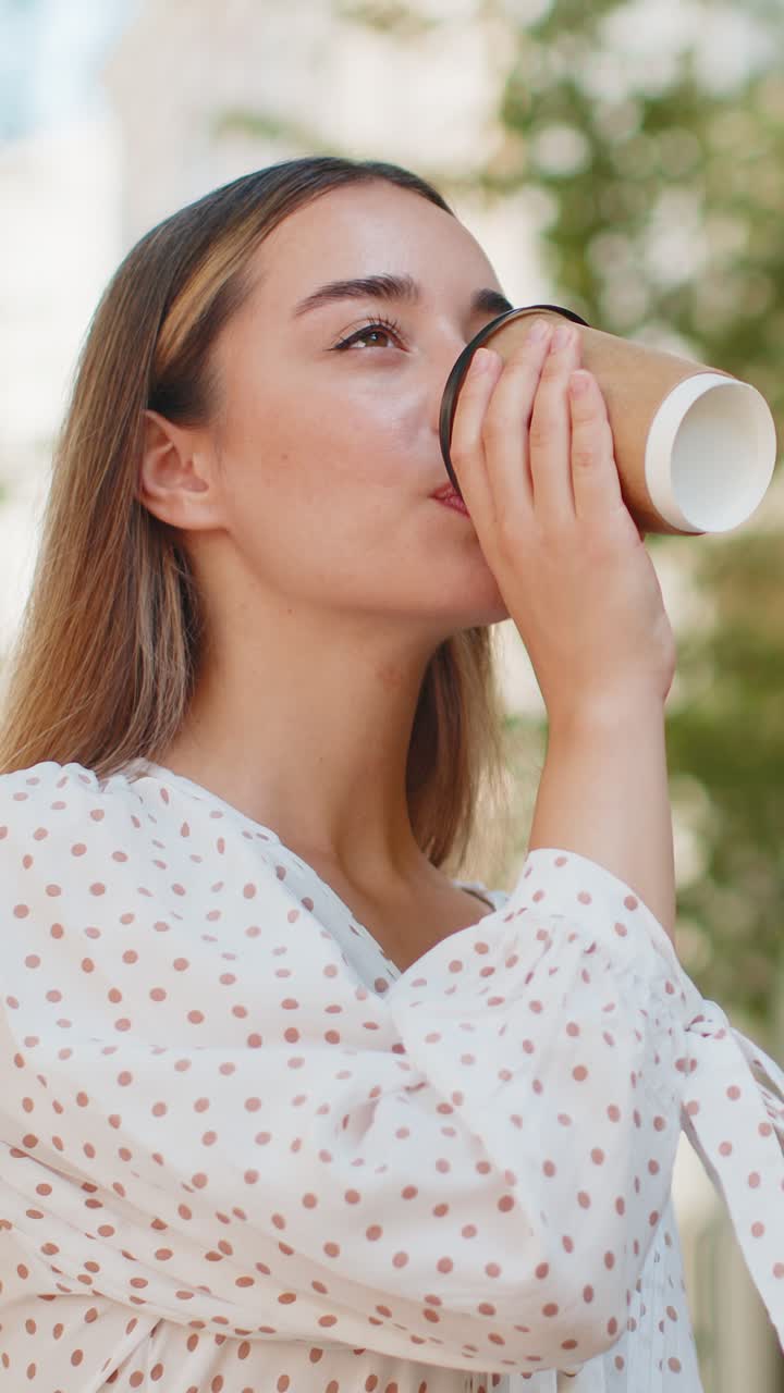 Joven caucásica sonriente disfrutando del café matutino, una bebida caliente y relajante durante un descanso