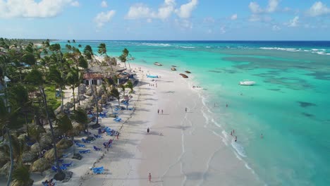 aerial forward of punta cana with people walking on beach. dominican republic