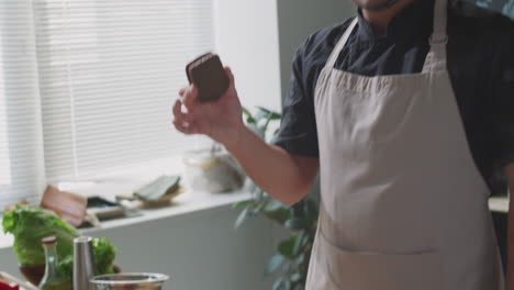 chefe a provar um brownie numa cozinha.