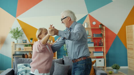 happy senior couple dancing at home