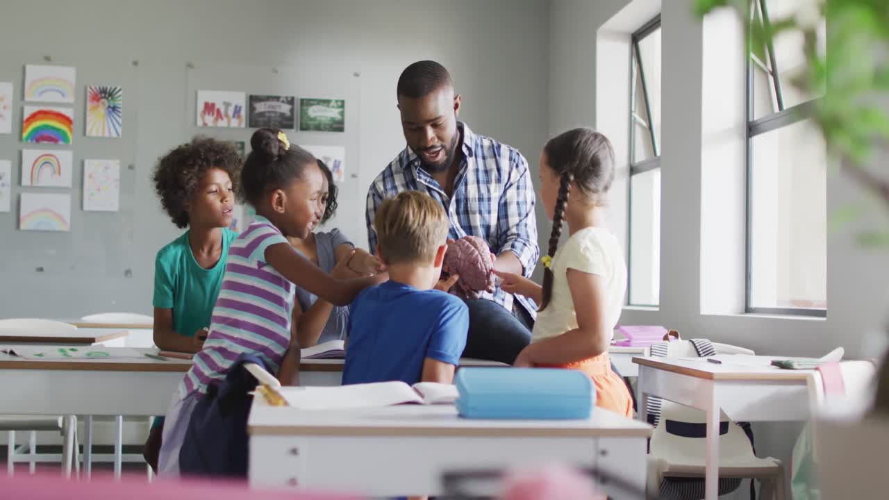 video de un feliz maestro afroamericano y una clase de alumnos diversos durante la lección de biología