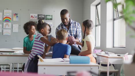 video of happy african american male teacher and class of diverse pupils during biology lesson