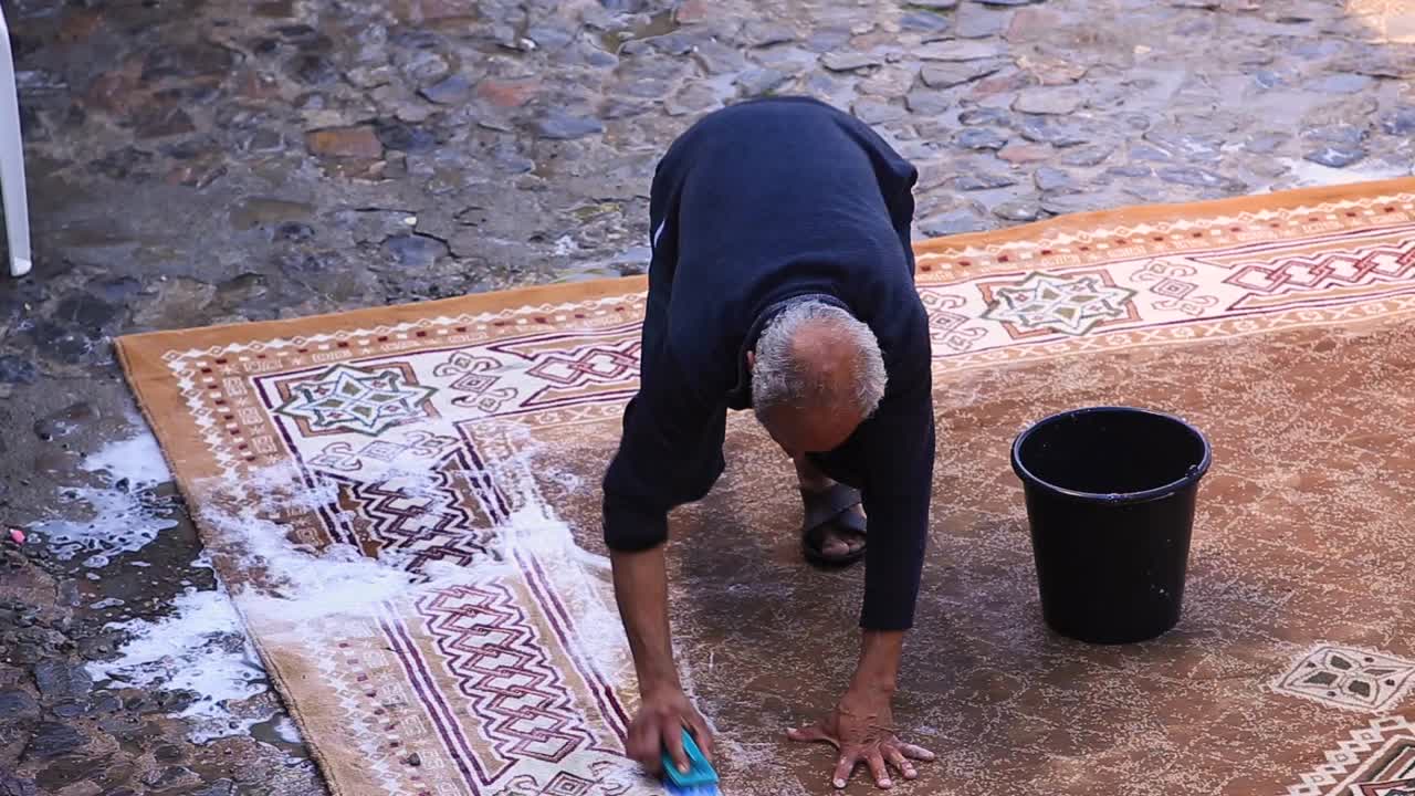 séquences montrant un homme lavant un tapis à Chefchaouen