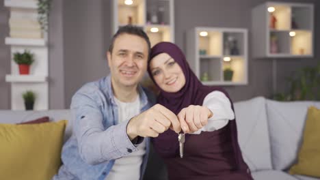 Muslim-woman-in-hijab-and-her-husband-become-house-owners,-house-keys.