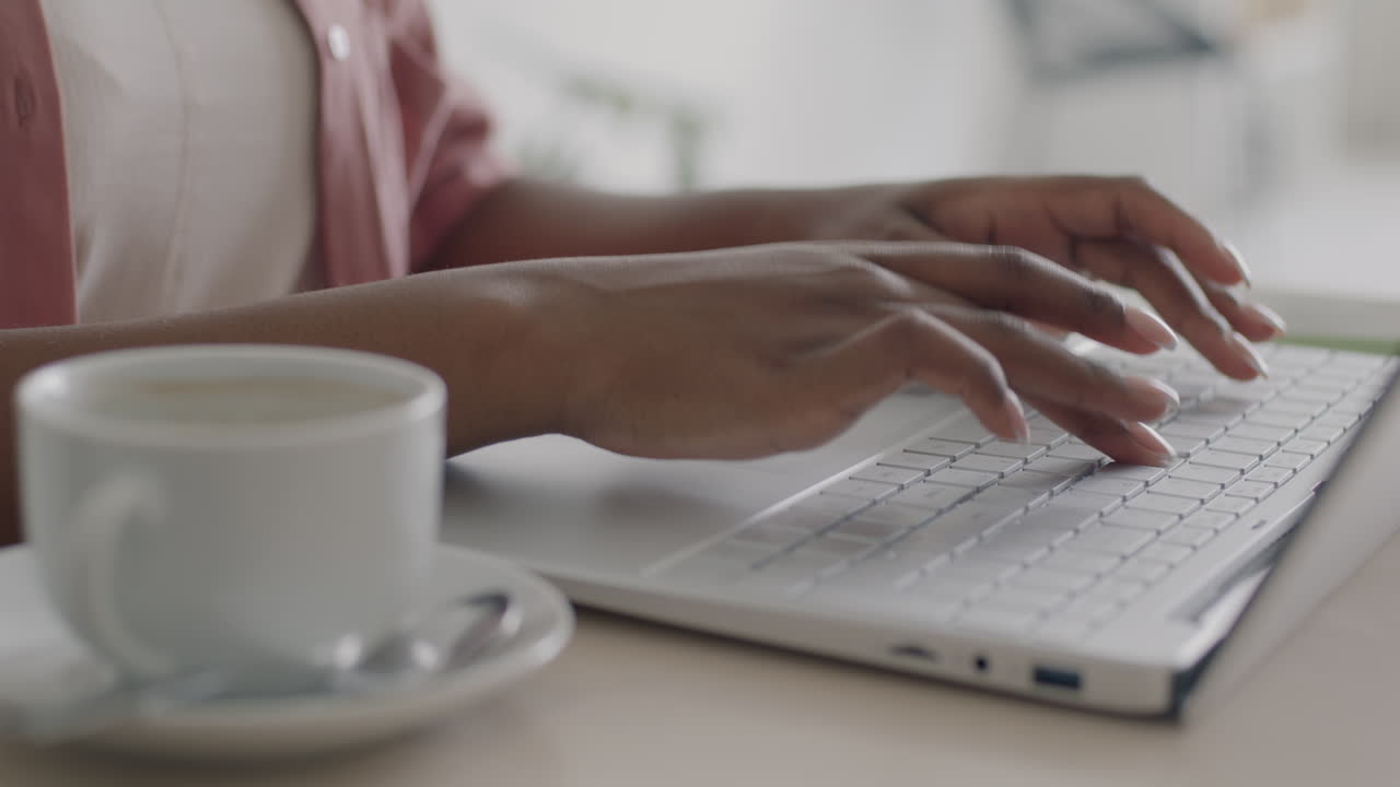 persona trabajando en una computadora portátil con café