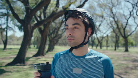 Cyclist Drinking Water and Having a Break Outdoors on Summer Day