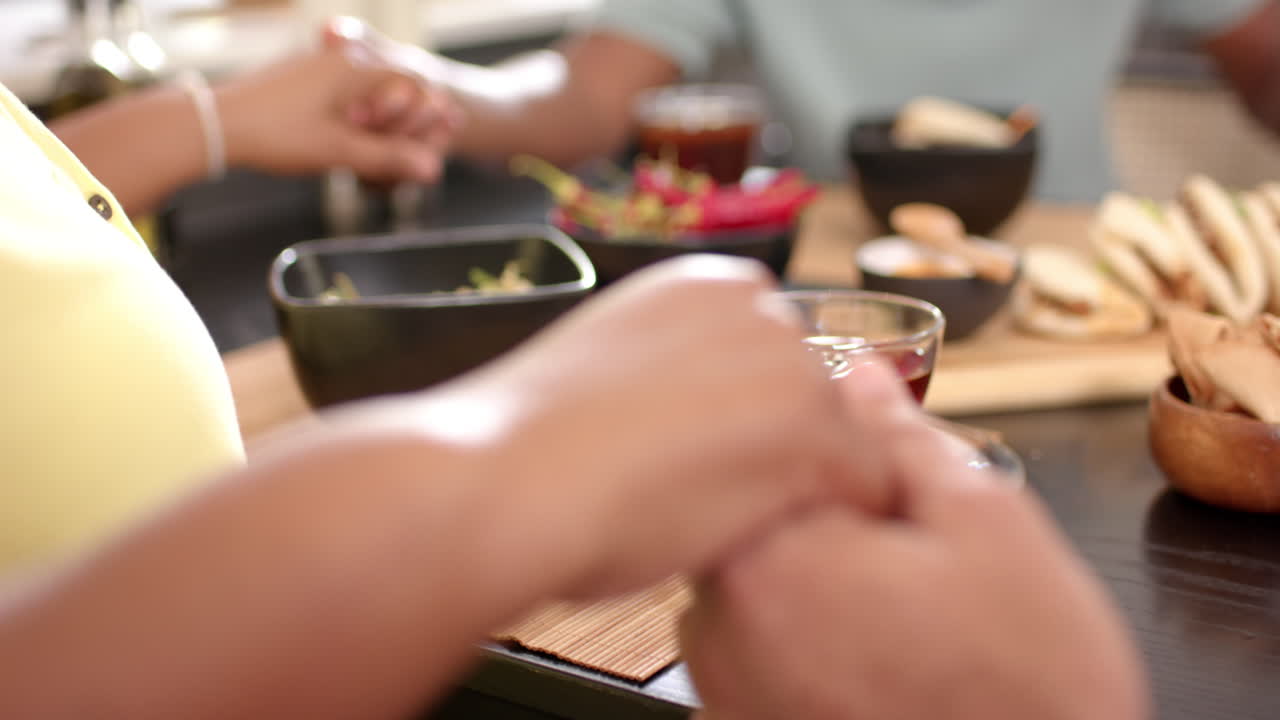 Holding hands, senior friends enjoying meal together at restaurant table