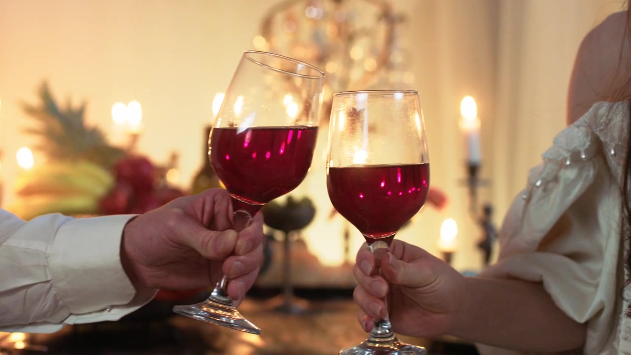 Brinde Romântico com Taças de Vinho Tinto em Ambiente à Luz de Velas.