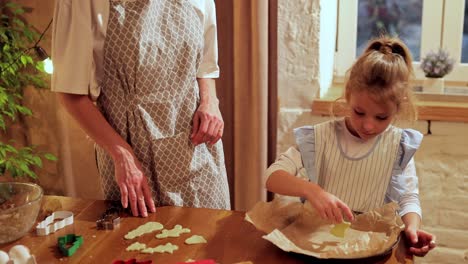 mom and daughter baking christmas cookies