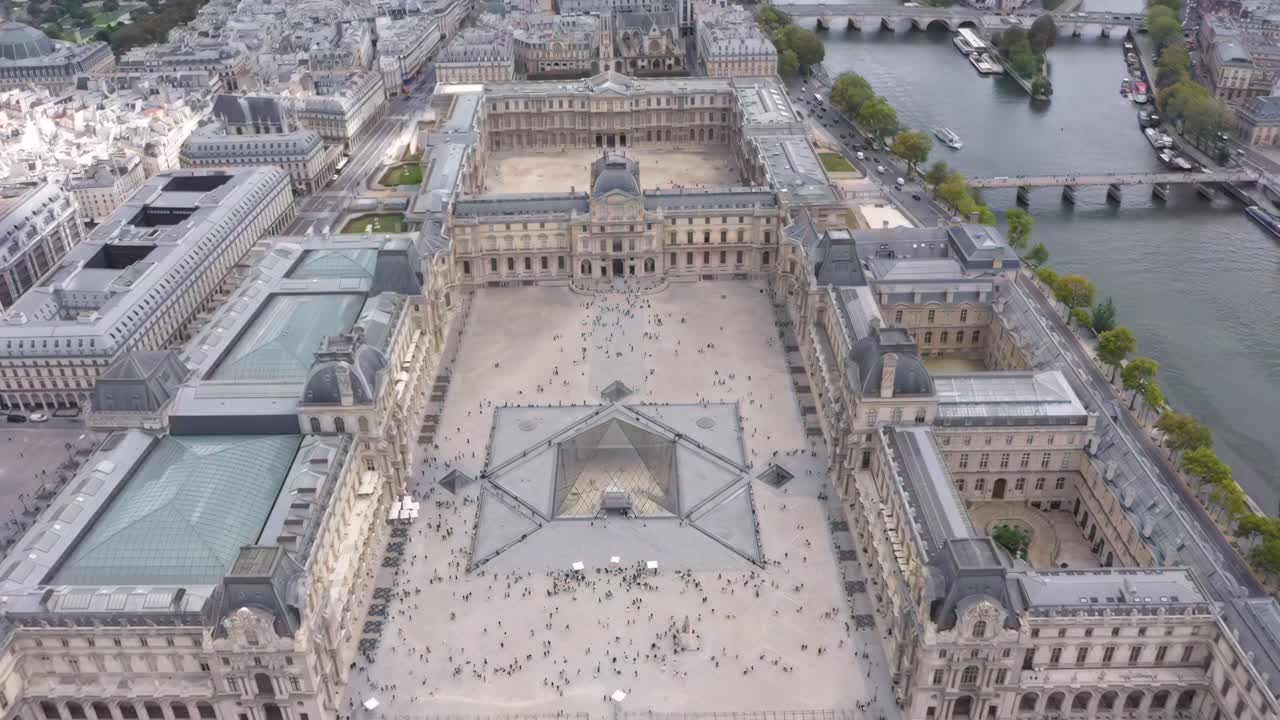 Aerial footage highlights the architectural brilliance of the Louvre Pyramid, complemented by the symmetry of the Tuileries Garden and the Seine River