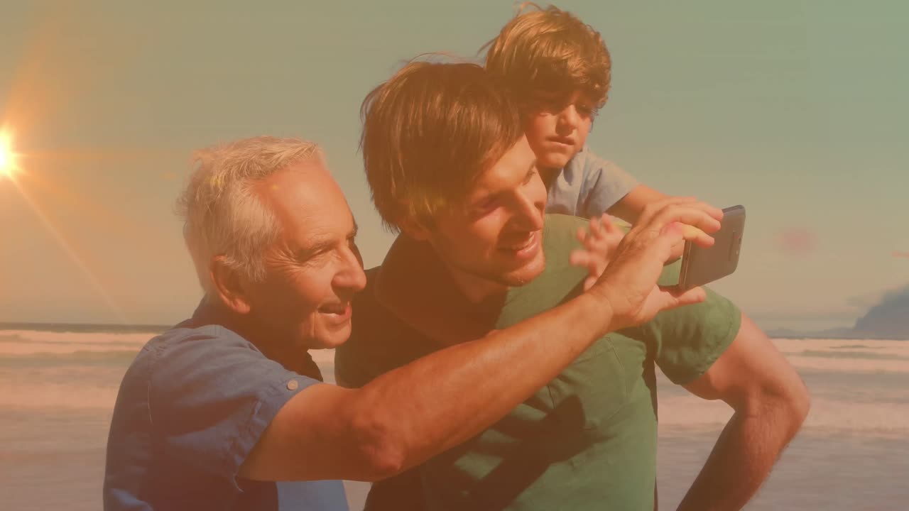 Animation of bokeh over happy grandfather, father and son taking selfie on beach