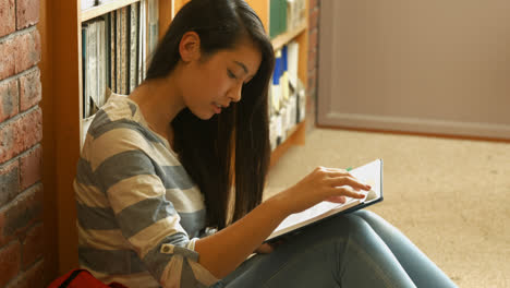 student reading a book in the library