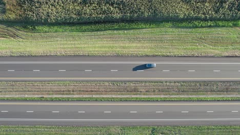 Drone-aerial-bird's-eye-view-over-traffic-movement-on-a-two-way-road-with-cars-on-a-sunny-day