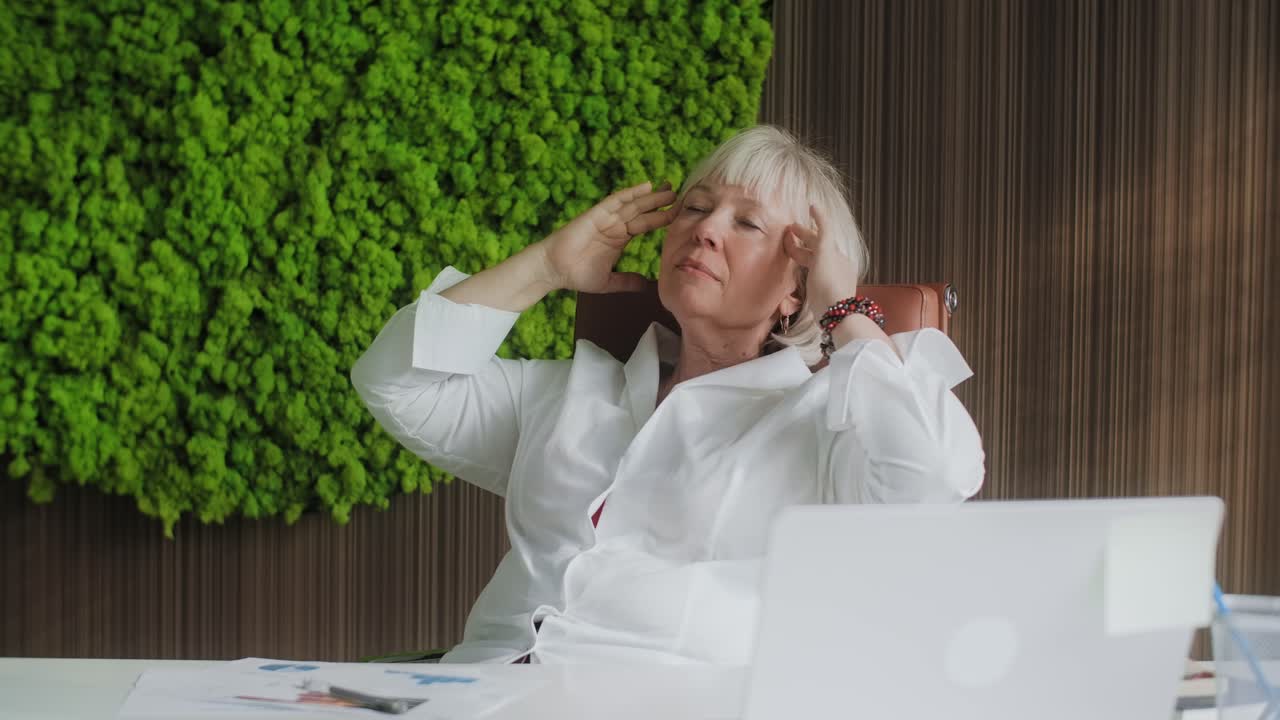 Stressed businesswoman relaxing at office desk