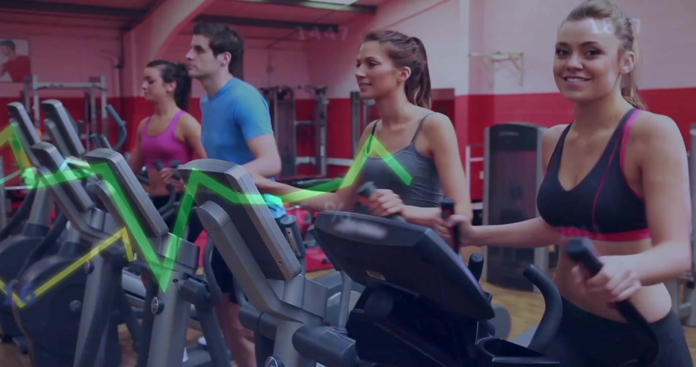Gruppo di persone che si allenano su macchine ellittiche in palestra.