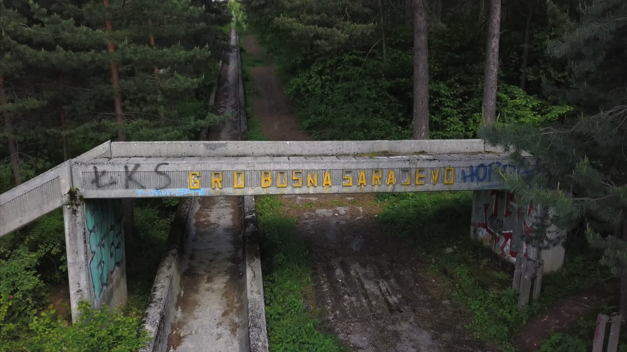 Aerial view of Sarajevo winter olympics bridge with Sarajevo written on it. Bosnia winter olympic old ruins bobsleigh and luge track.