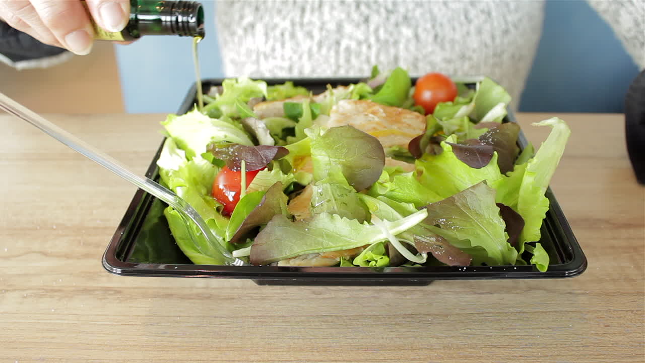 샐러드에 올리브 오일을 뿌린 여자