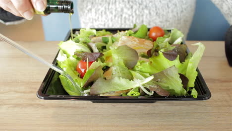 mujer haciendo pucheros con aceite de oliva en la ensalada